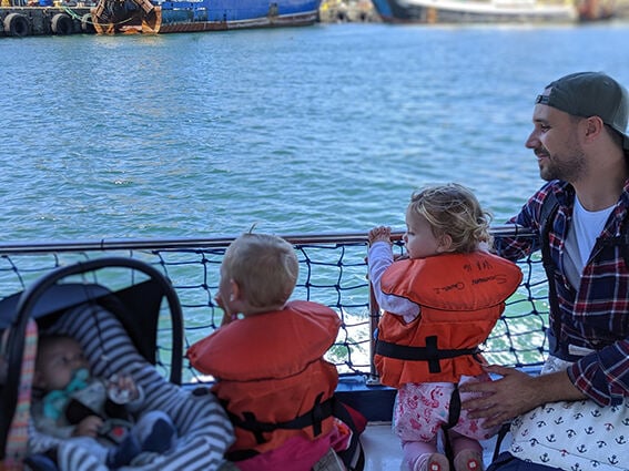 Mann mit  3 Kindern auf einem Boot